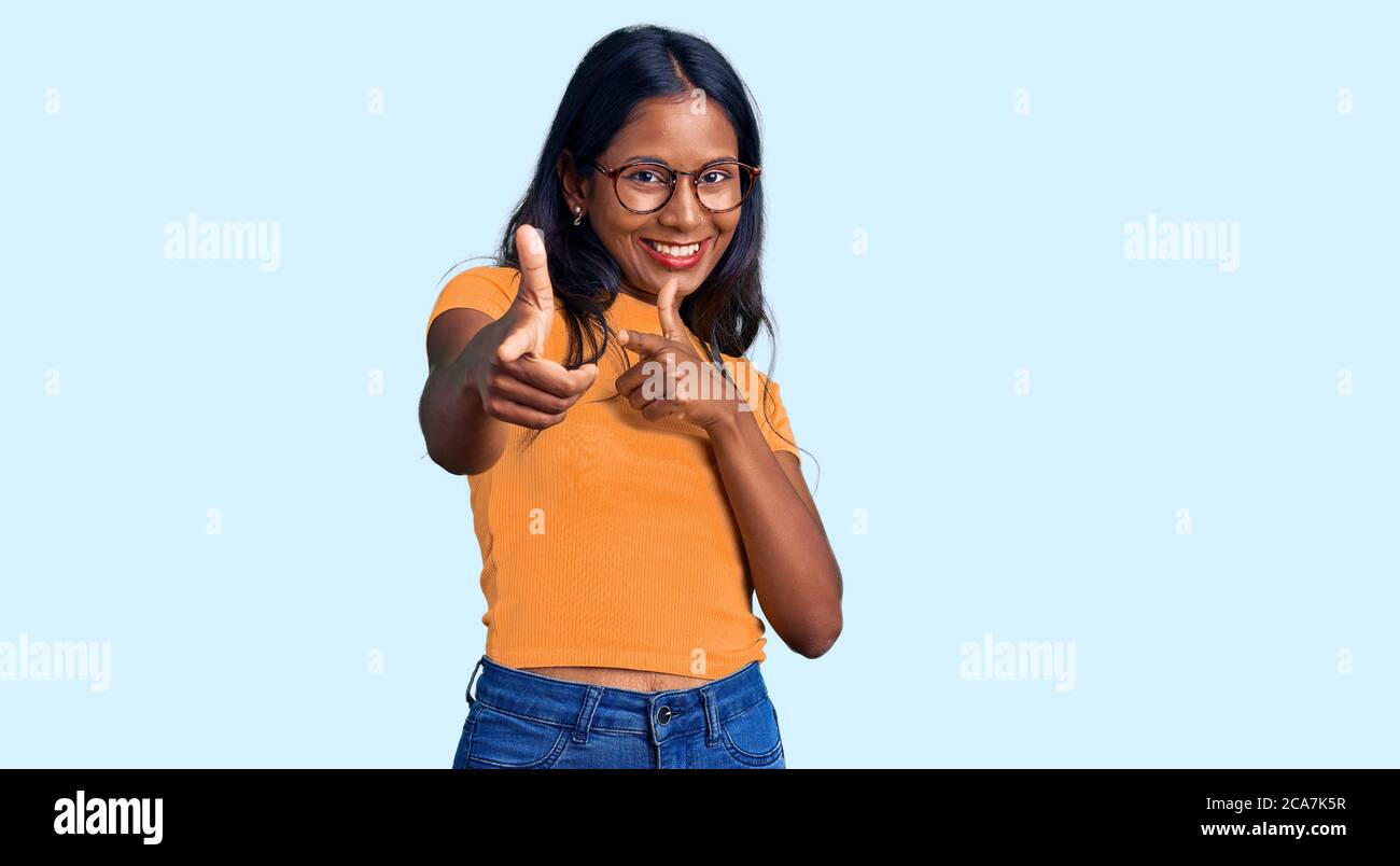 Young indian girl wearing casual clothes and glasses pointing fingers to  camera with happy and funny face. good energy and vibes Stock Photo - Alamy