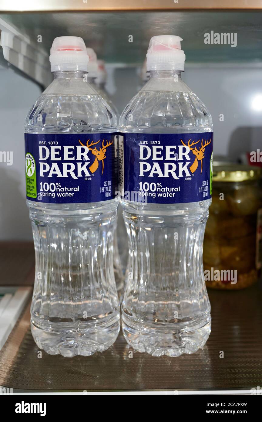 Plastic Deer Park spring water bottles on a refrigerator shelf. Stock Photo