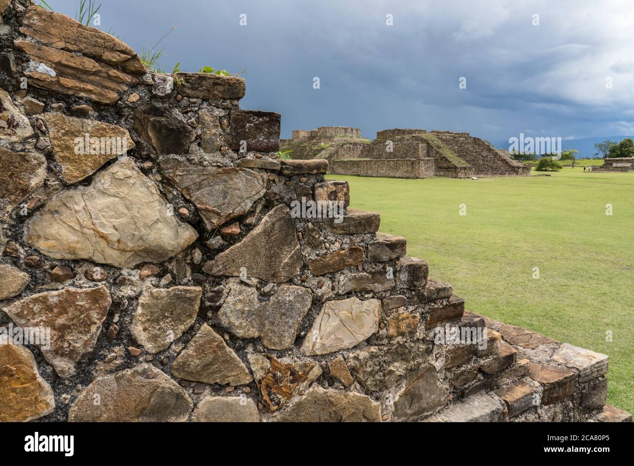 Detail of the stone steps leading to the ball court, looking across the Grand Plaza at Buildings G and H at the pre-Columbian Zapotec ruins of Monte A Stock Photo