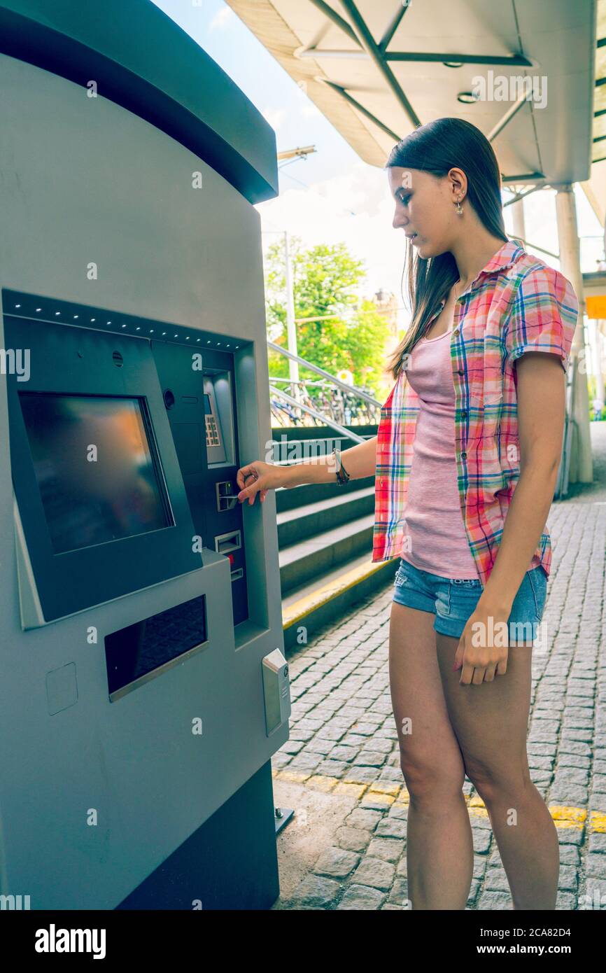 Young woman uses a vending machine for transport tickets Stock Photo ...