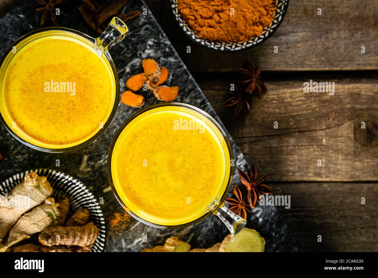 Turmeric golden milk and ingredients on wood background Stock Photo