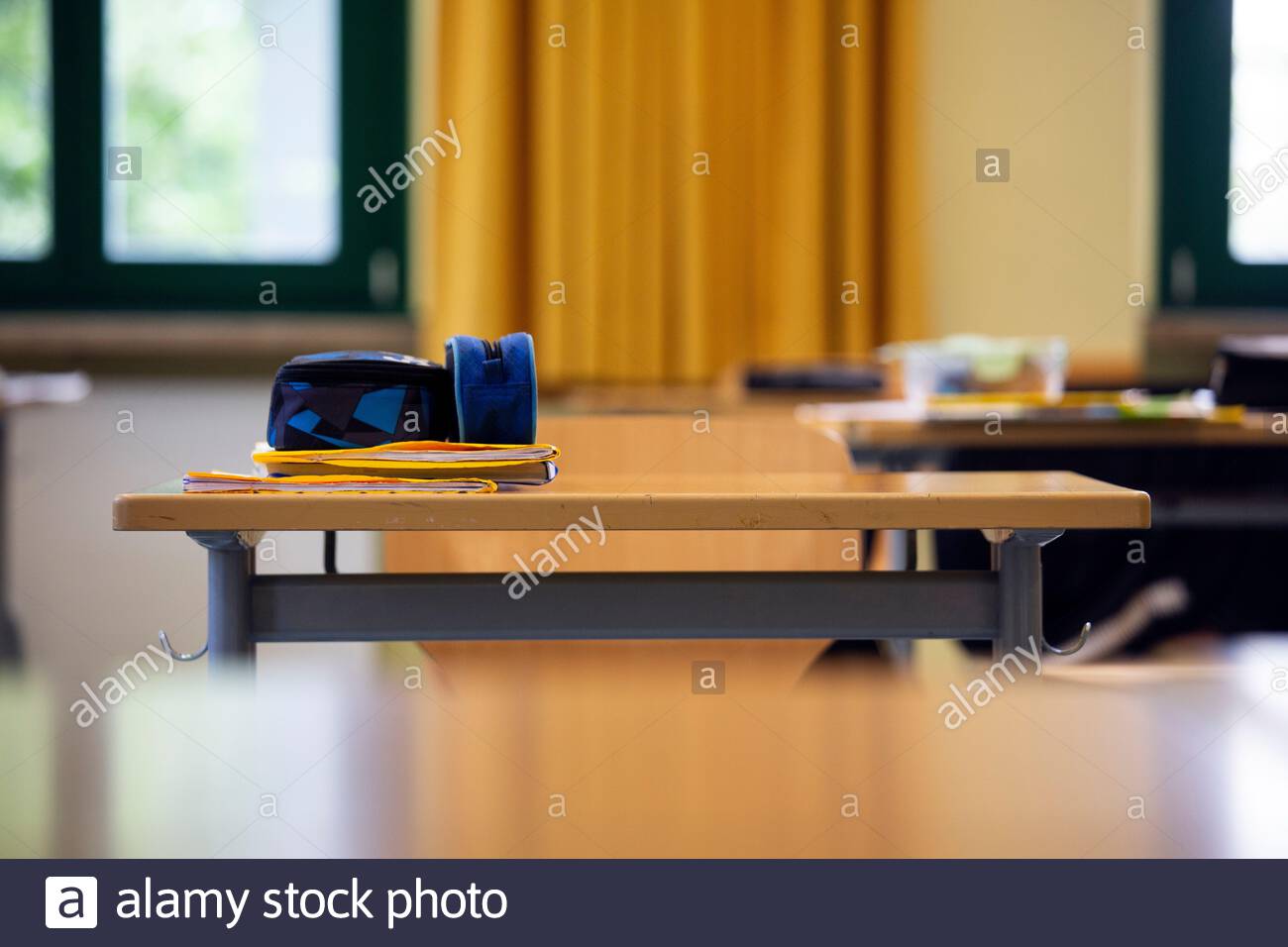 A student's copy and pencil case on a desk in a German secondary school classroom during the Corona crisis. Covid 19 has caused schools to adapt. Stock Photo