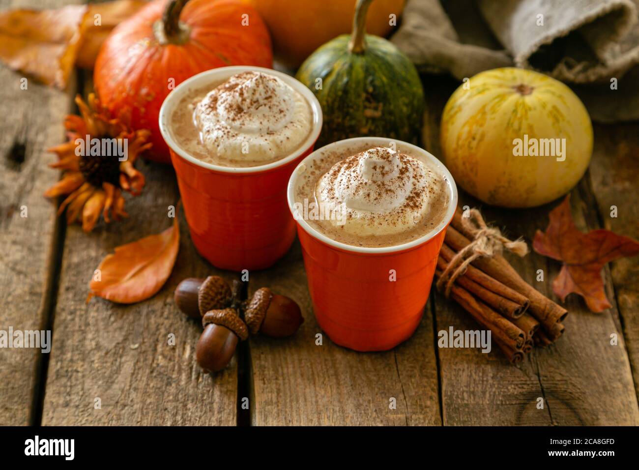 Pumpkin spiced latte in orange glasses on wood background Stock Photo