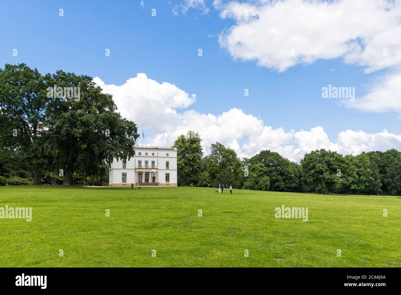 Jenischpark, public park at Hamburg, with Jenisch House, a classicist villa today acting as a museum and exhibition hall. People and dogs on the lawn Stock Photo