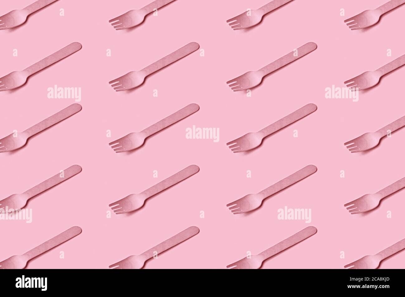 Plastic-free, zero waste, eco friendly disposable cutlery made of wood. Wooden fork flat lay, seamless pattern. Modern stylish design in trendy pink. Stock Photo