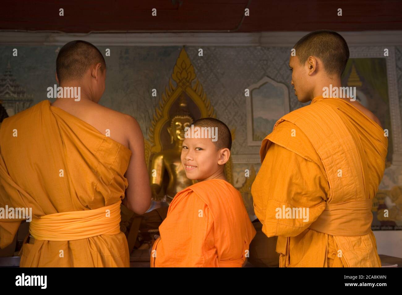 Young Buddhist Monk looking back and Smiling at a temple in Bangkok,Thailand. Stock Photo