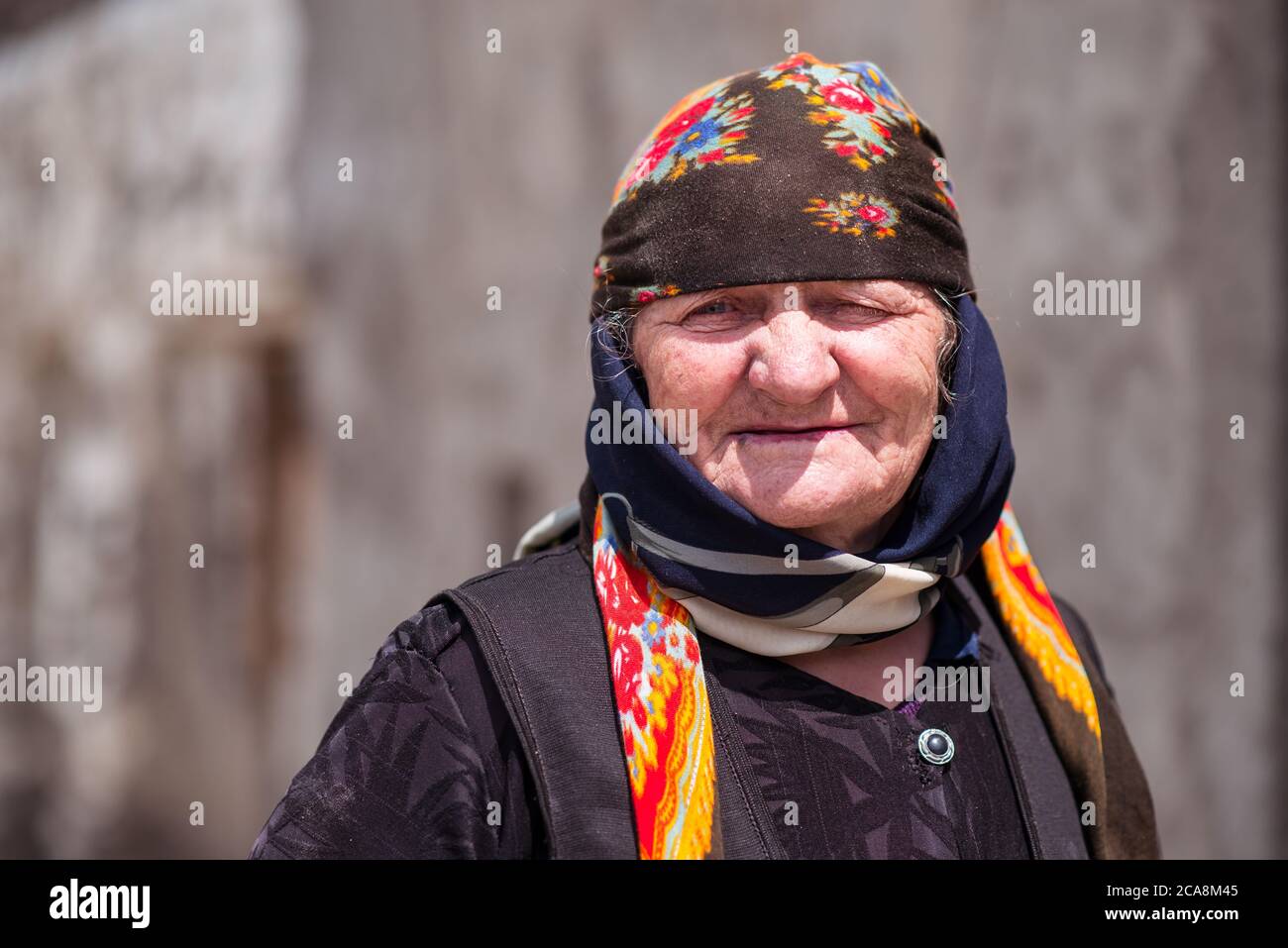 Xinaliq / Azerbaijan - July 8, 2019: Portrait of old woman with colorful head scarf in mountain village Stock Photo