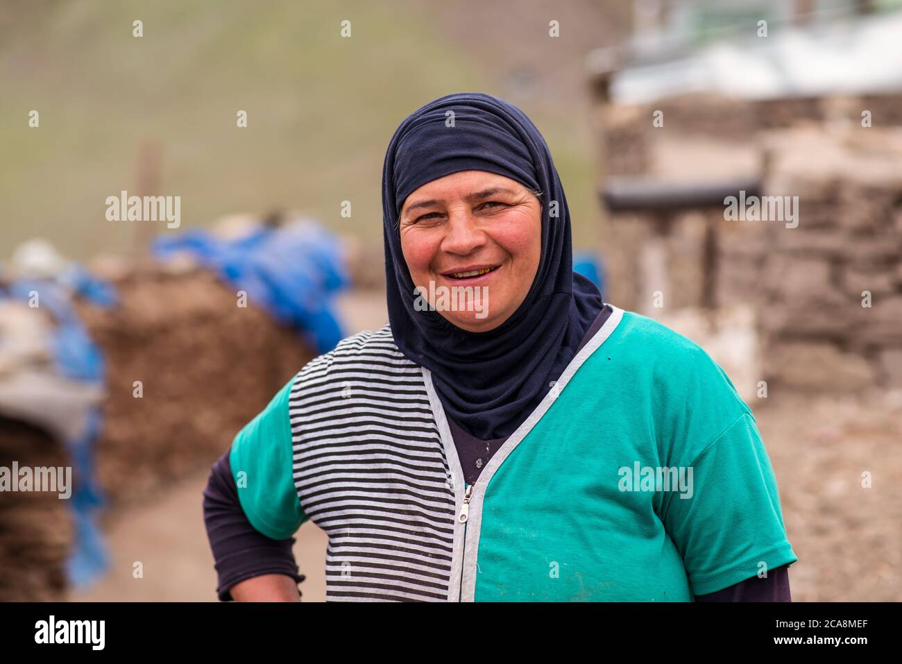 Xinaliq / Azerbaijan - July 8, 2019: Portrait of smiling Muslim woman with green dress in mountain village Stock Photo