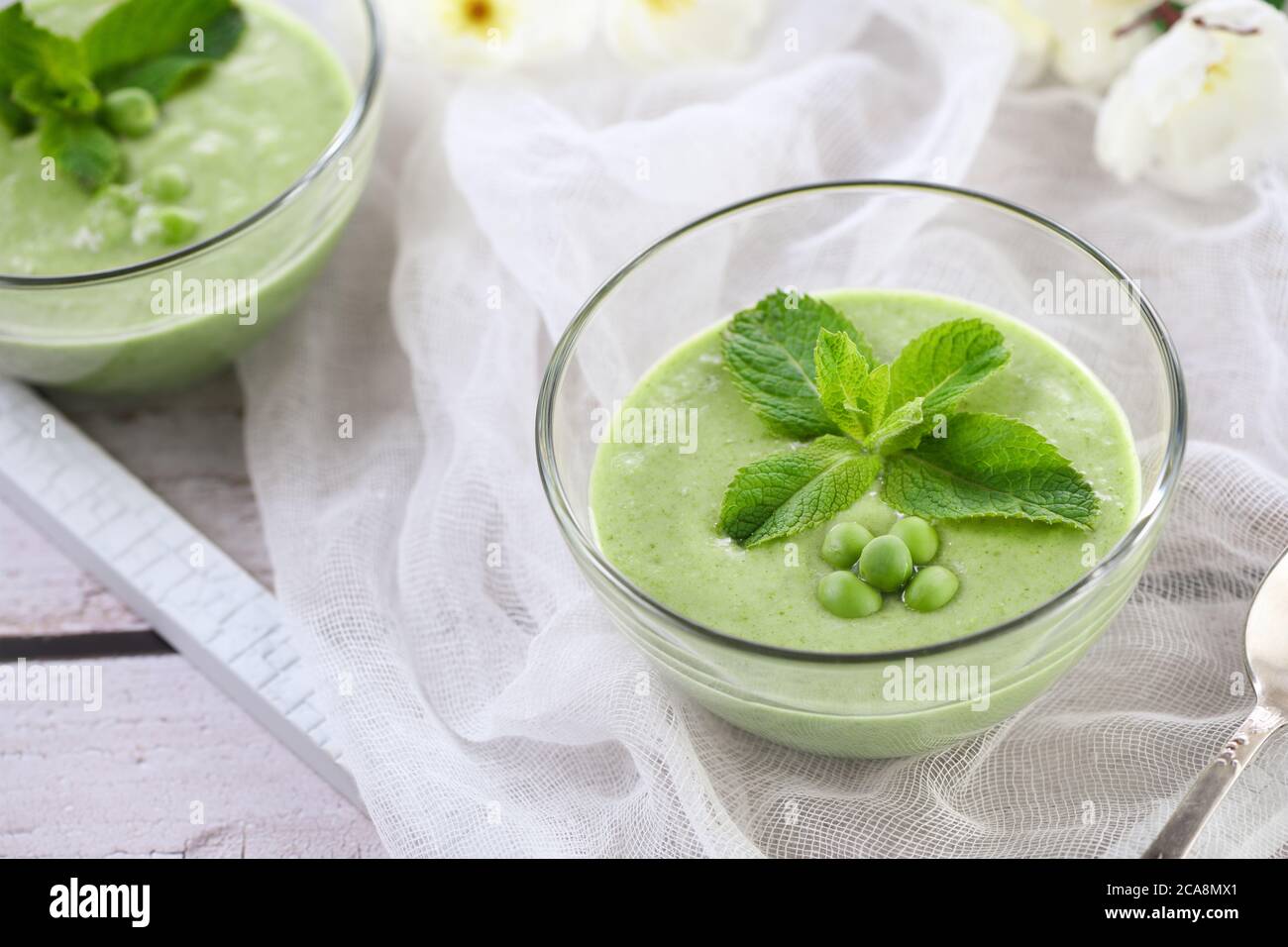 Chilled green pea puree soup with tender milk cream and refreshing mint