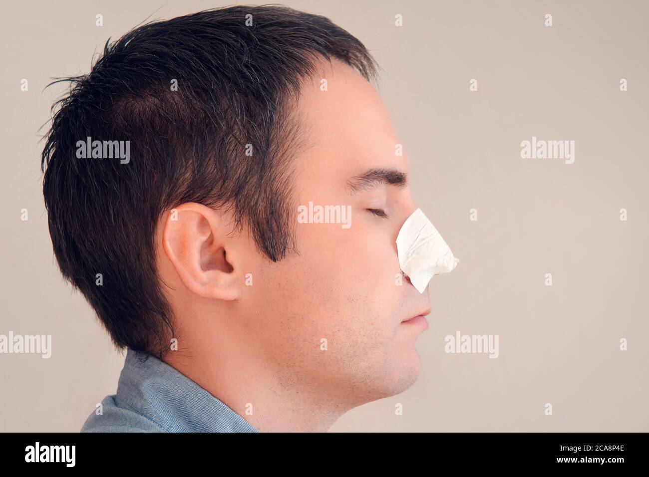 man puts on and removes a strip for the nose from black dots. Coal cleaning strips from blackheads and comedones. concept of personal care. Stock Photo