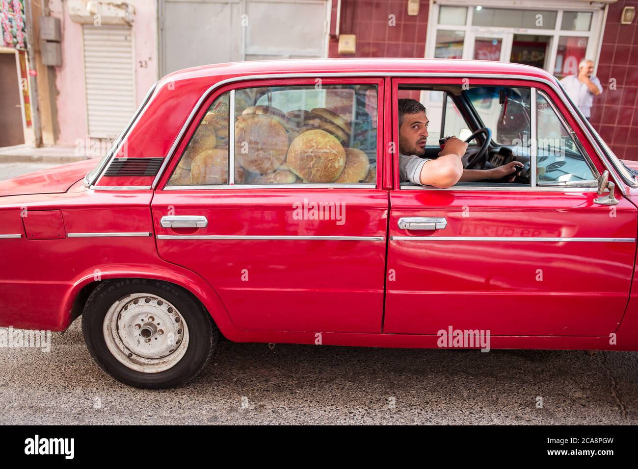 Baku / Azerbaijan - June 7, 2019: man transporting bread in a red lada Stock Photo