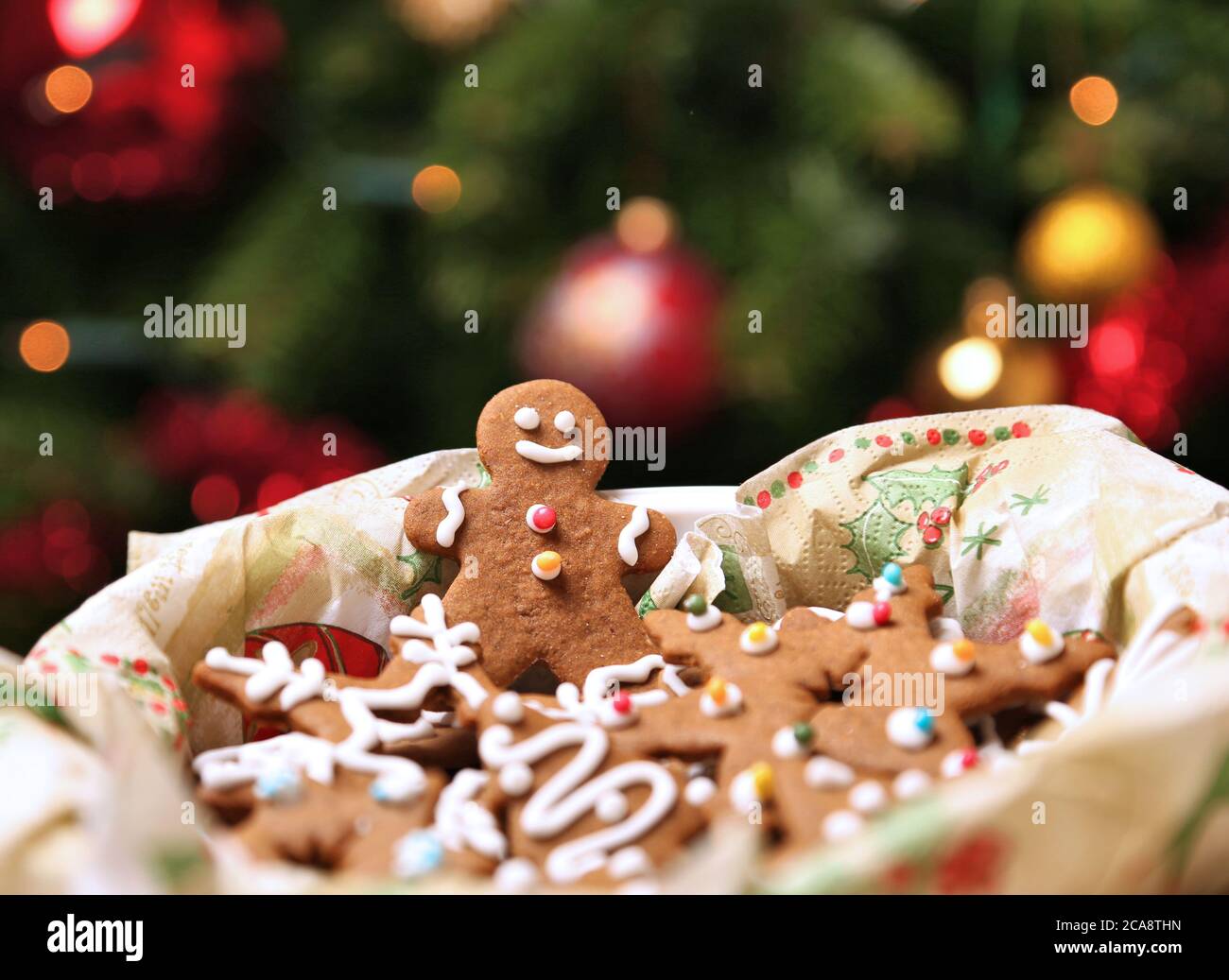 Gingerbread cookies box under the Christmas tree. Gingerbread man smiling. Stock Photo