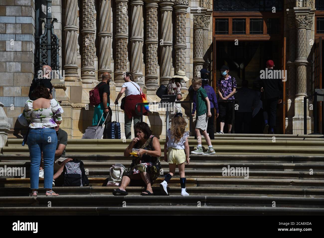 People queue outside the Natural History Museum in South Kensington