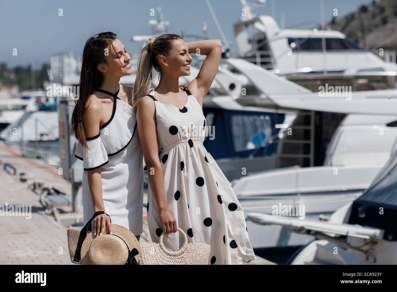 Portrait of a two beautiful young smiling woman outdoor near sailing ...