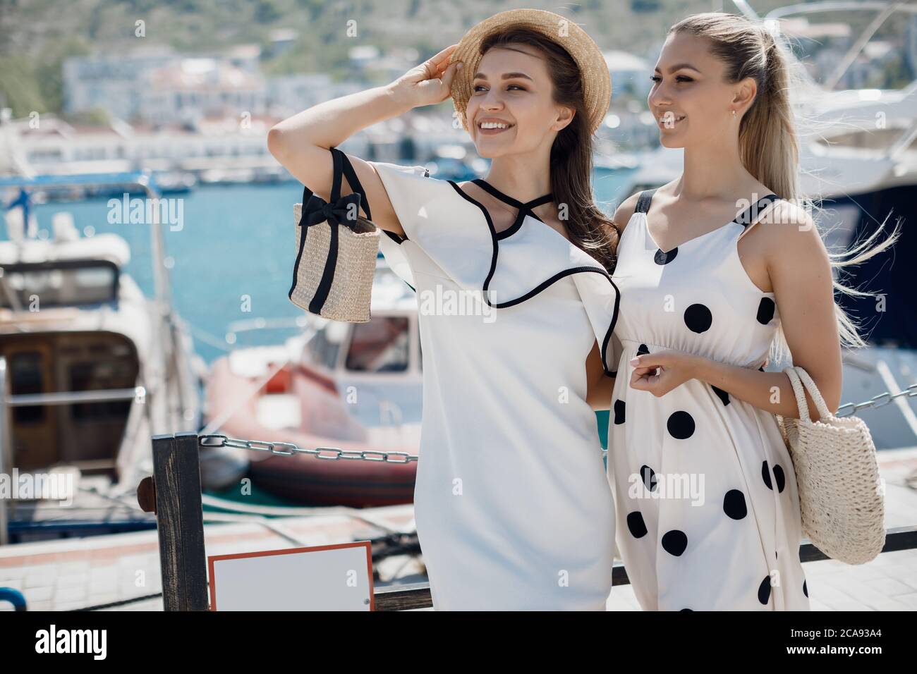 Portrait of a two beautiful young smiling woman outdoor near sailing ...