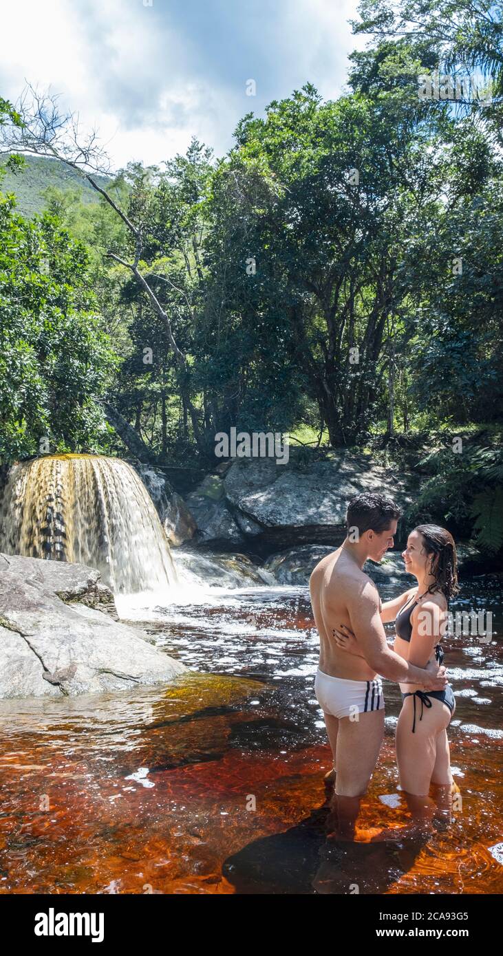 A young heterosexual Latin couple in love enjoying a swim in a mountain stream in pristine rainforest, Minas Gerais, Brazil, South America Stock Photo
