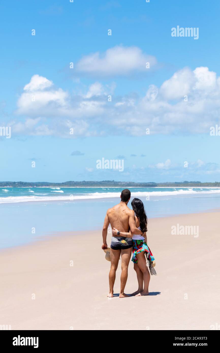 A good-looking Hispanic (Latin) couple on a deserted beach with backs to camera, Brazil, South America Stock Photo