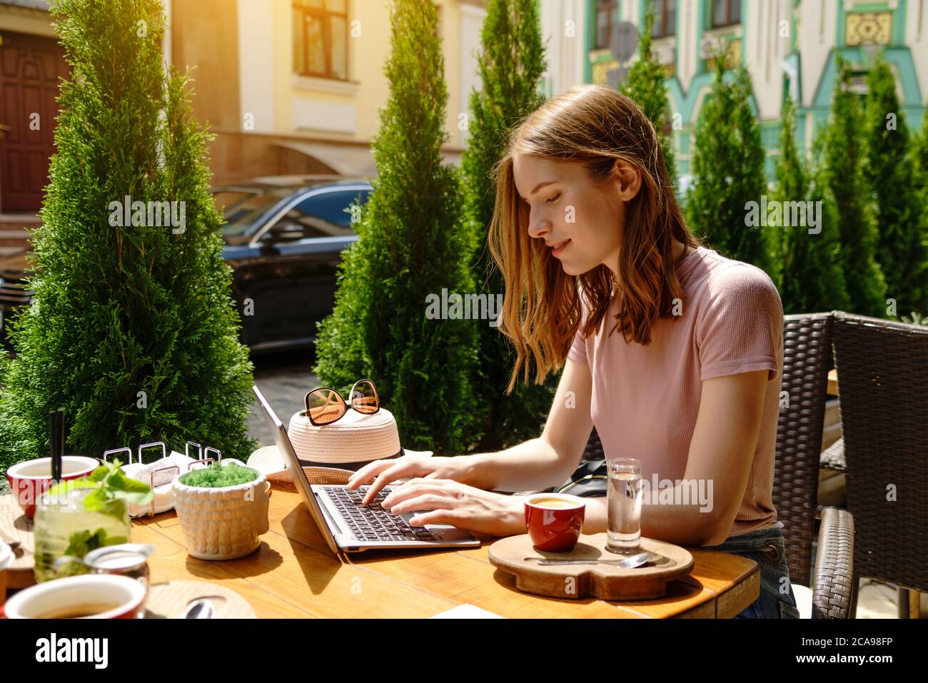 young woman using laptop in a cafe on a summer terrace Stock Photo - Alamy