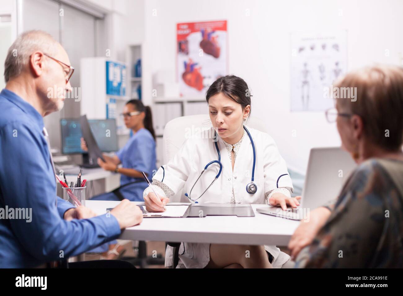 Young doctor writing prescription for sick senior couple during medical