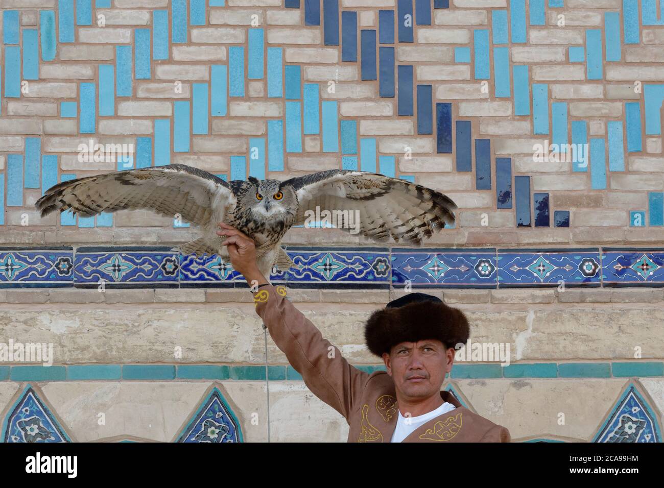 Kazakh man in traditional clothes displaying his eagle owl (Bubo Bubo), Turkistan, South region, Kazakhstan Stock Photo