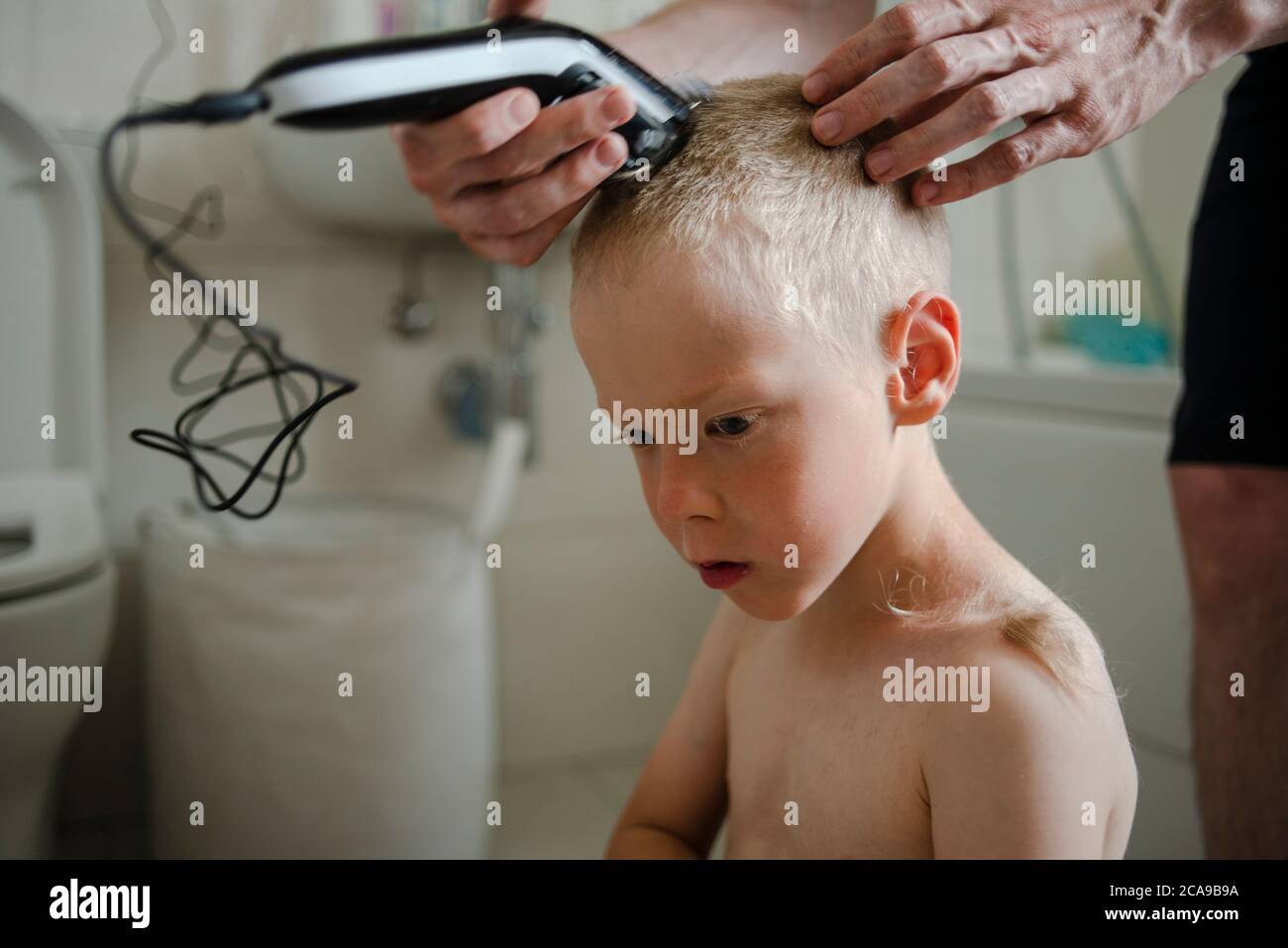 Father making haircut for son at home with haircut machine in bathroom  Stock Photo - Alamy, image size:1300x957