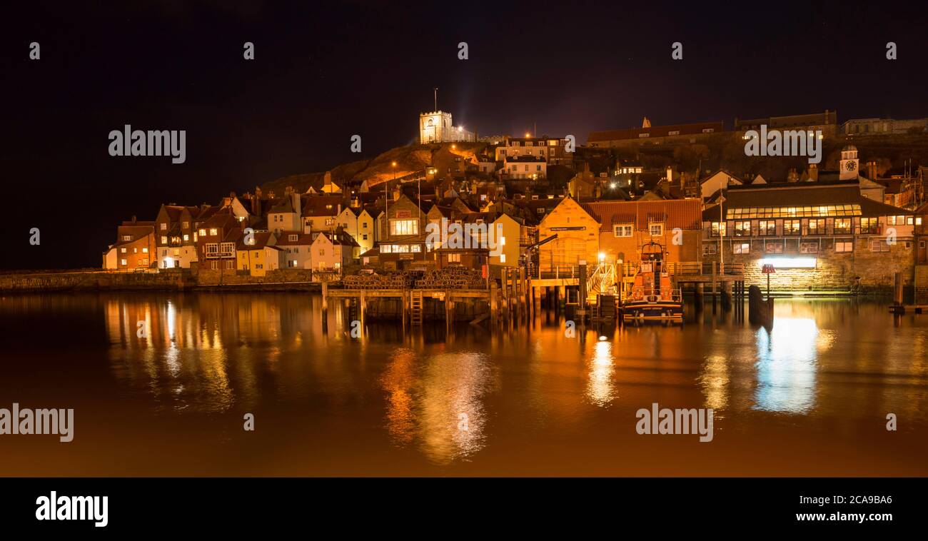 Night time view of the River Esk, East Cliff and lifeboat station in Whitby, Yorkshire coast Stock Photo