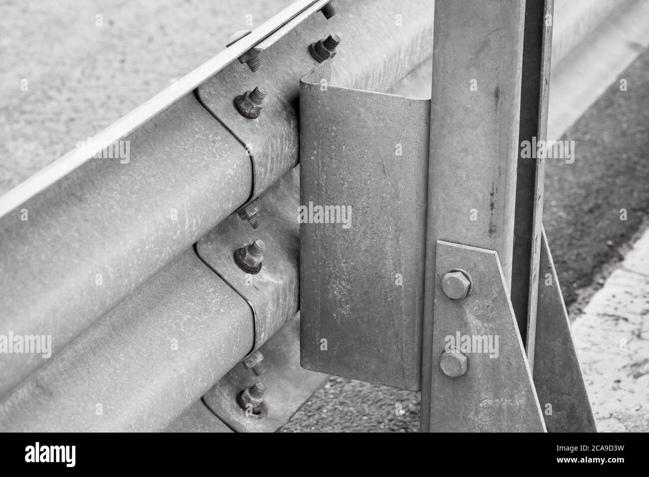 Gray metal guardrail construction mounted on a highway roadside Stock Photo