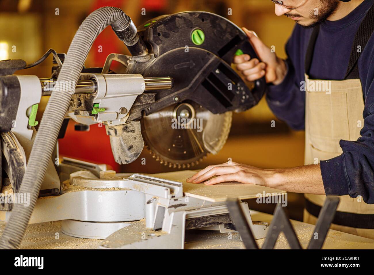 young caucasian hard working carpenter using circular saw, craftsman