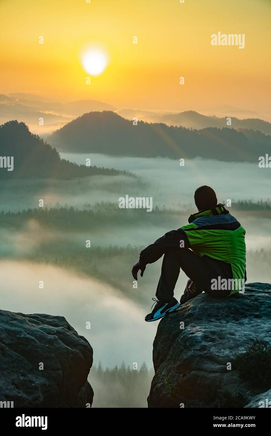 Alone hiker man sitting on a rock and enjoying spectacular view. Pure nature Stock Photo
