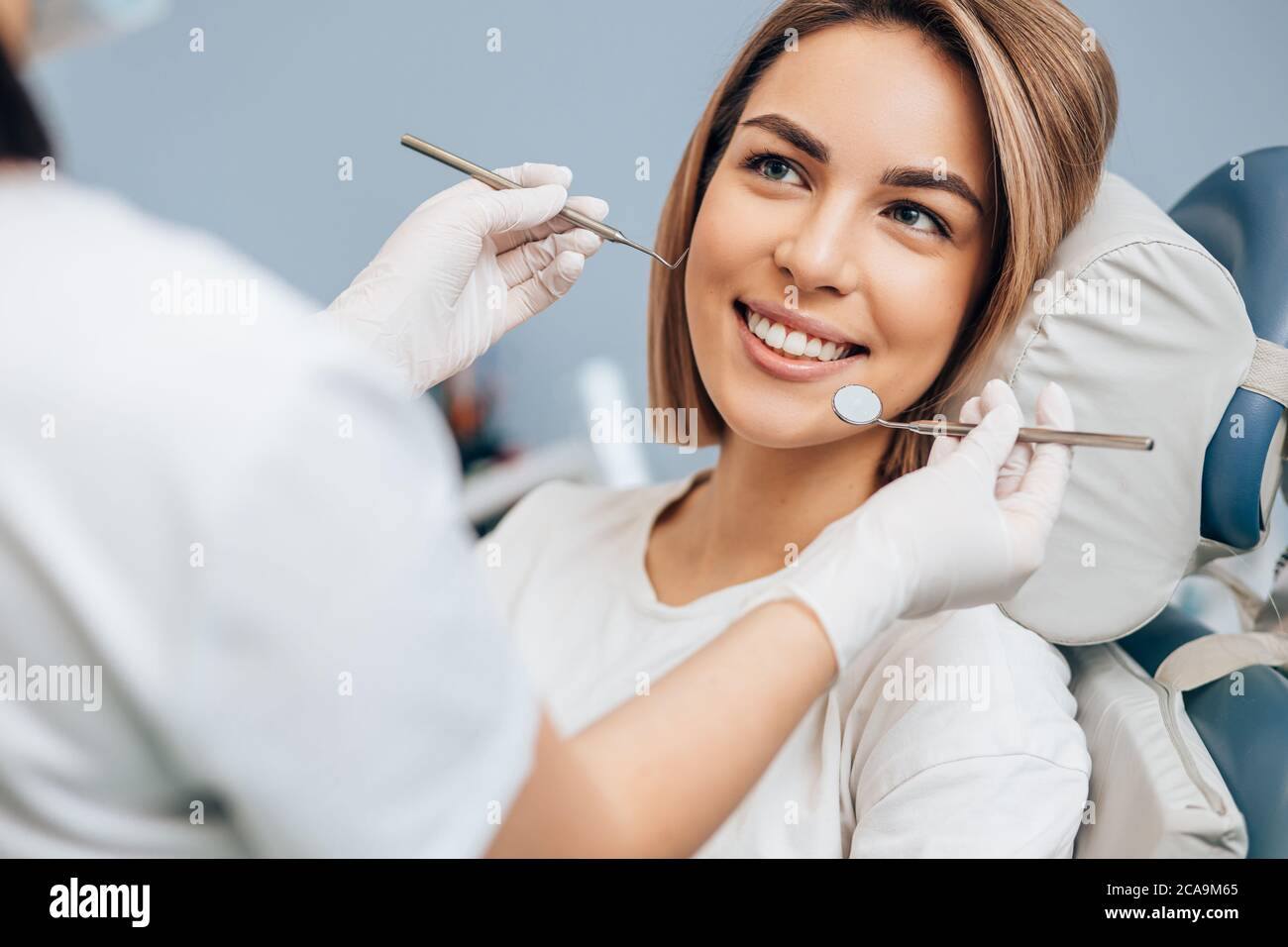 goodlooking woman with short hair sit in dental office and look at