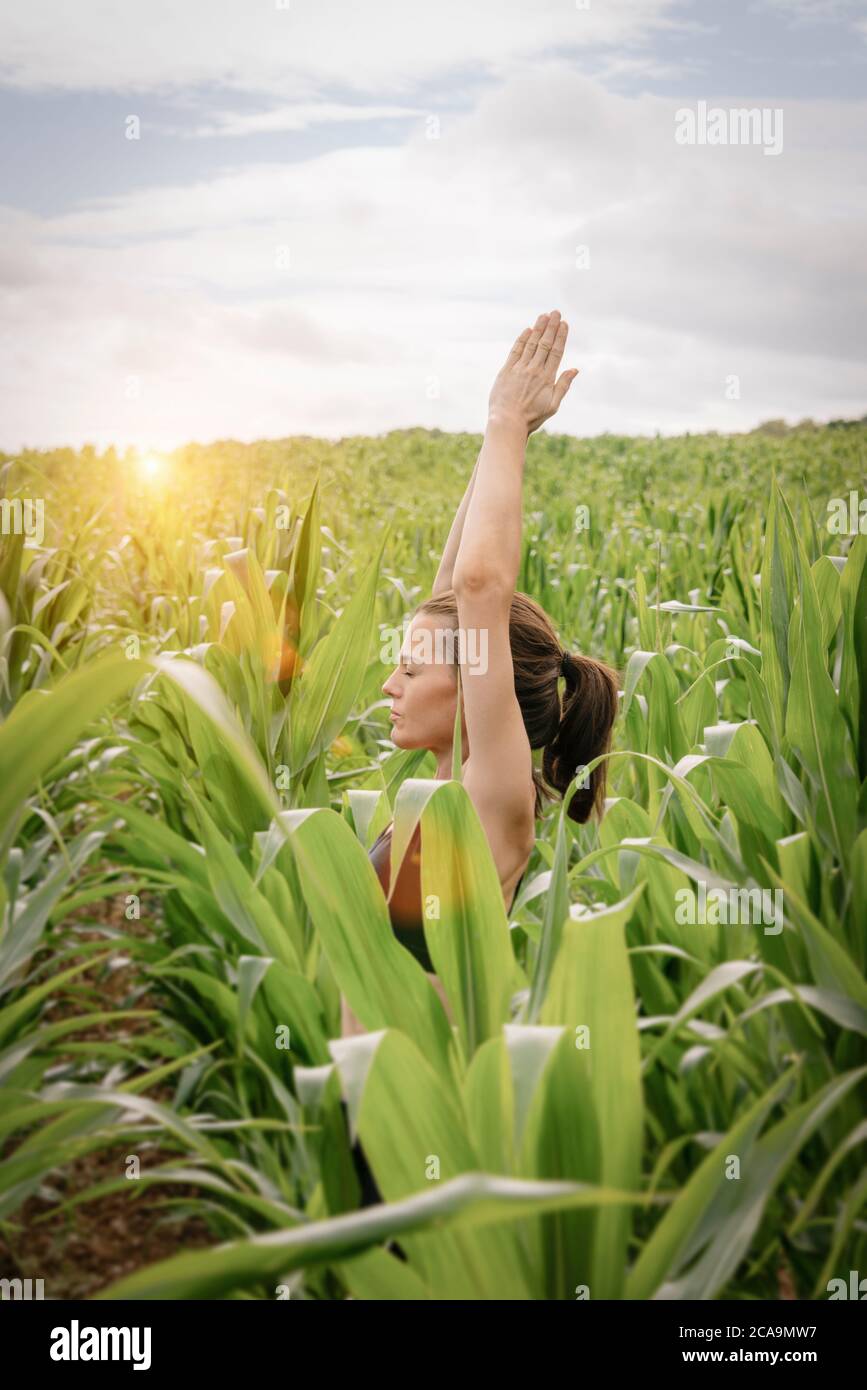 Woman meditating and practicing yoga outdoors in nature. Stock Photo