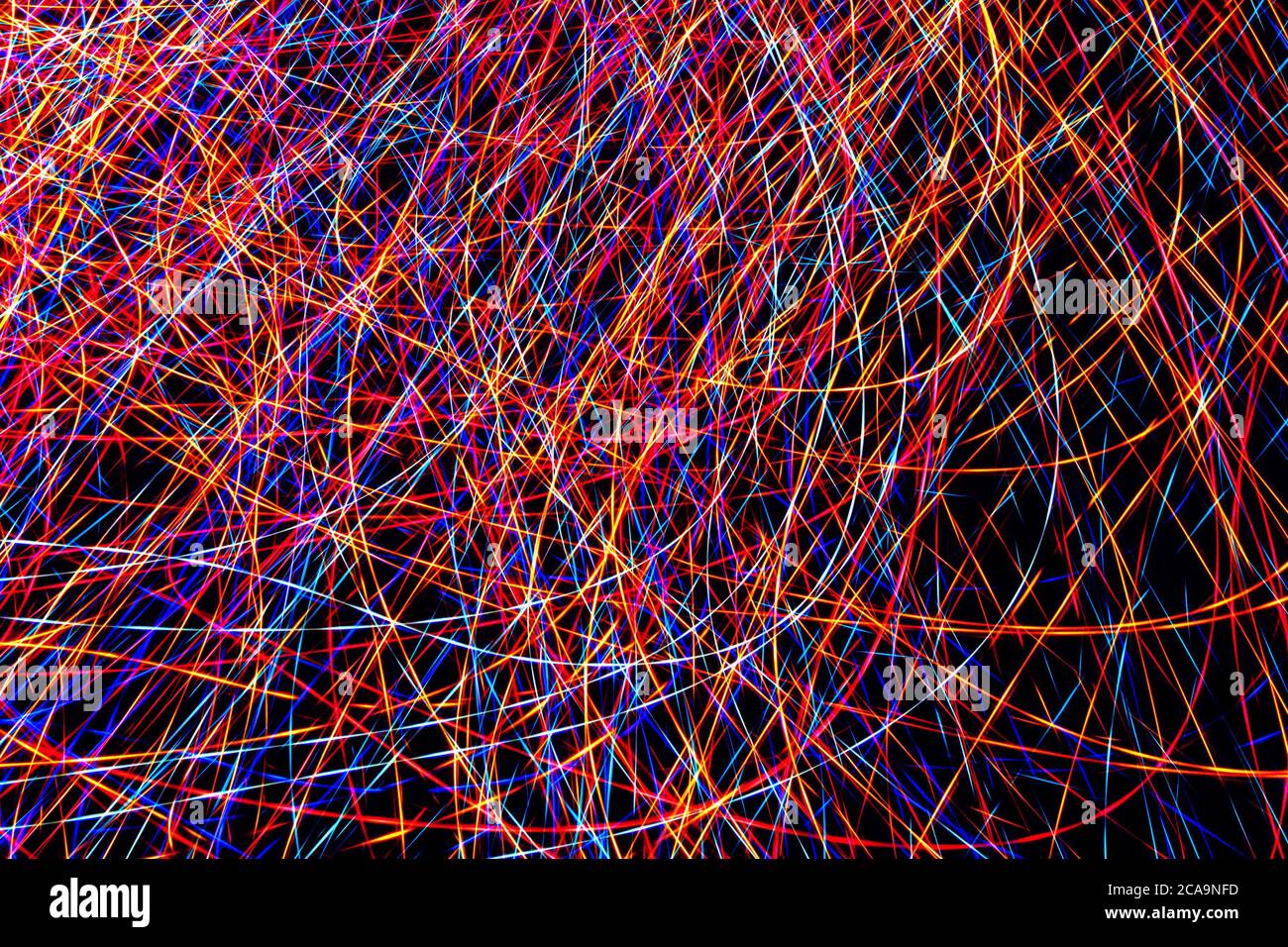 Colorful light painting abstract long exposure image with pink, blue, red and yellow lines on a black background Stock Photo