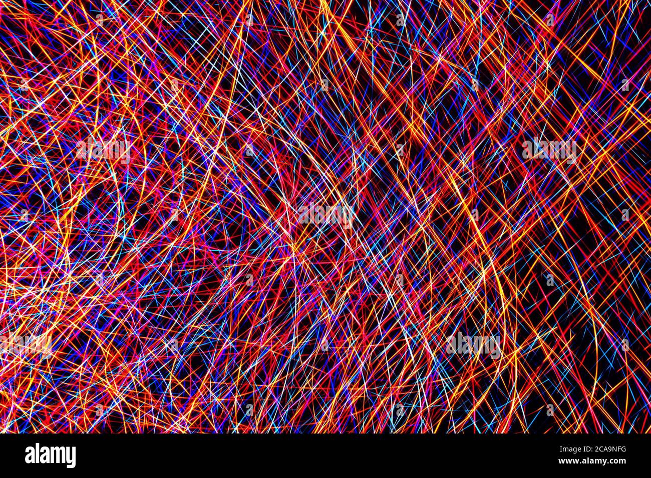Colorful light painting abstract long exposure image with pink, blue, red and yellow lines on a black background Stock Photo