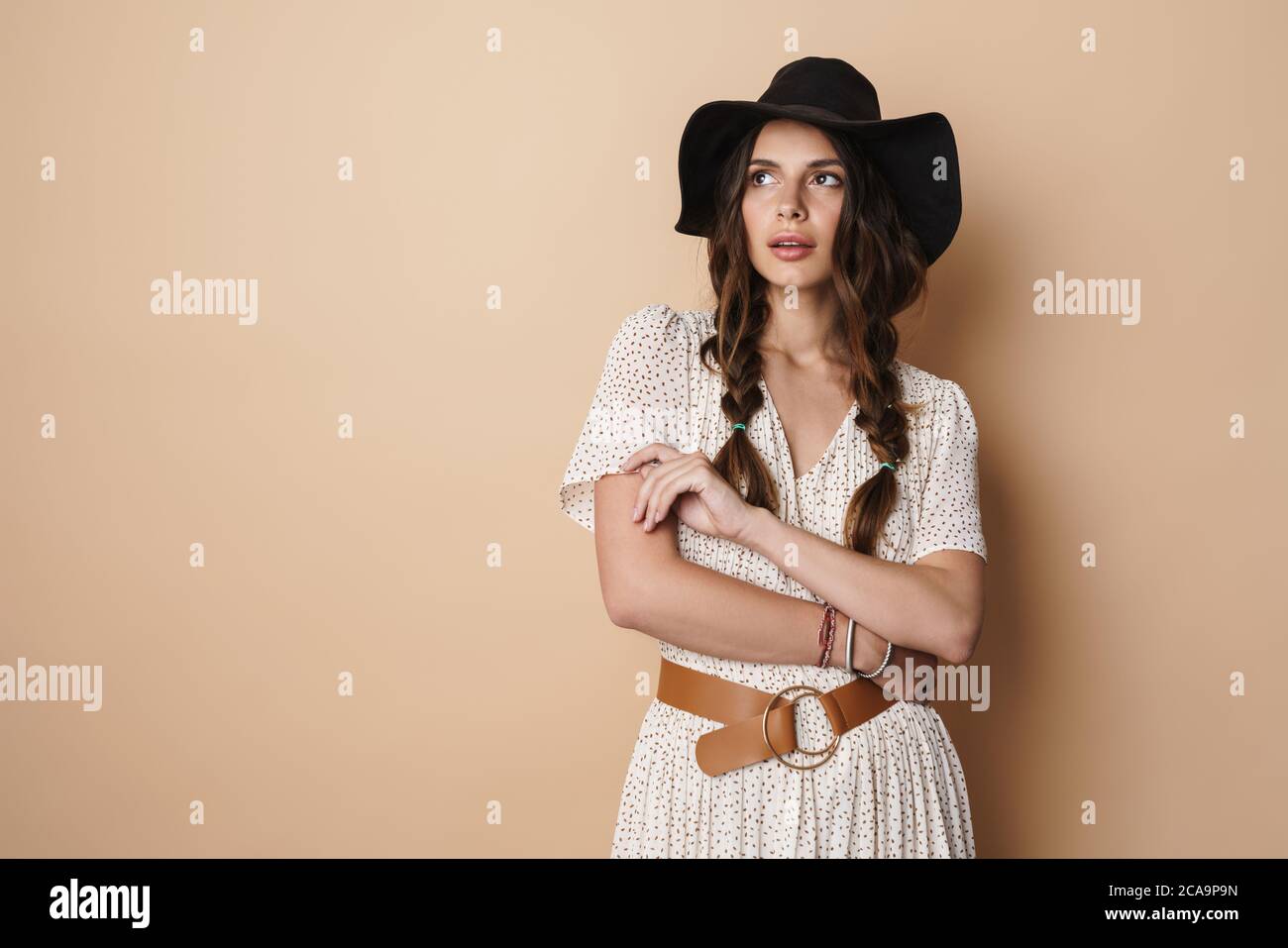 Photo of thinking beautiful woman in hat posing and looking upward ...