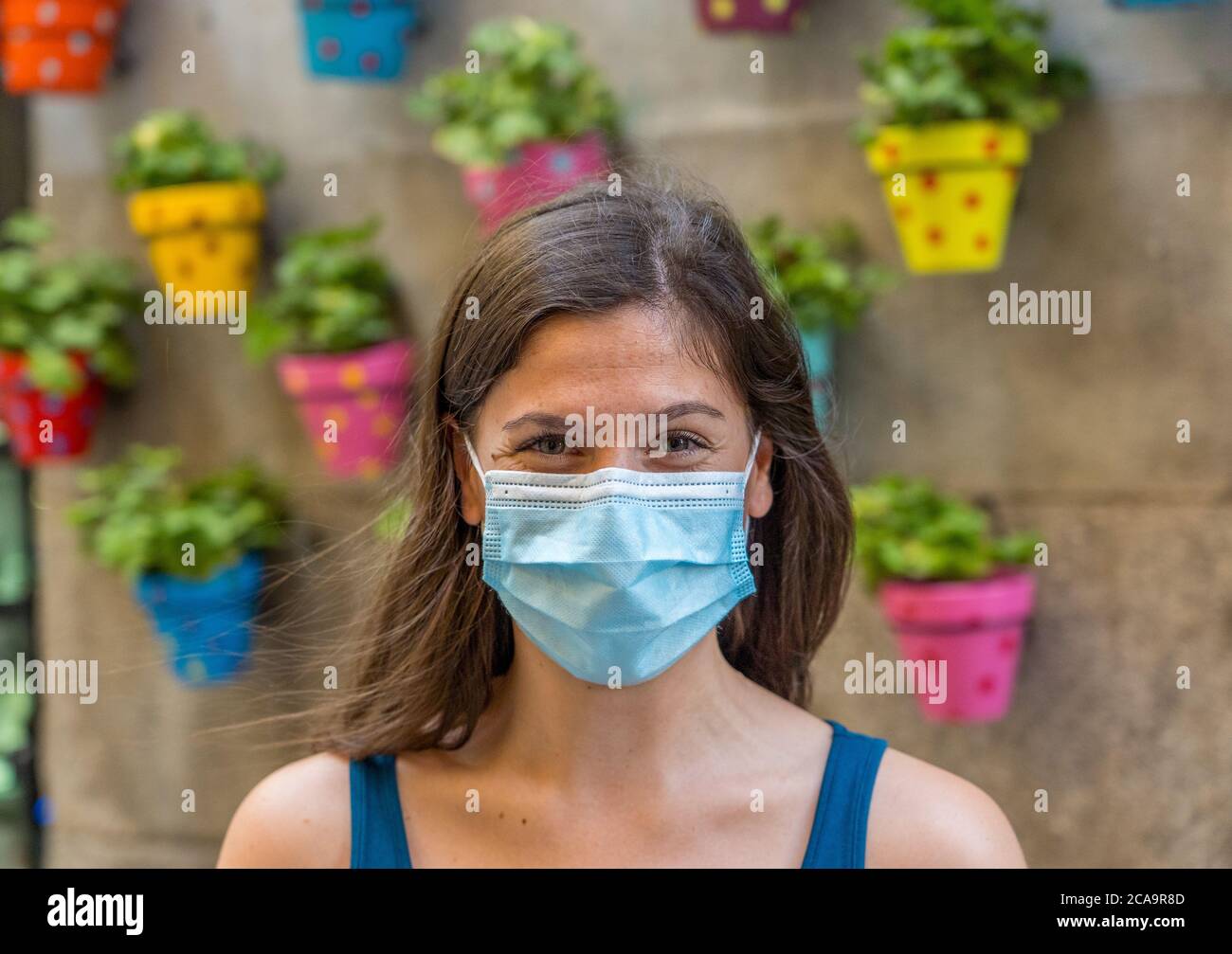Young woman wearing surgical mask on face in public spaces. Coronavirus spreading protection mask protective against influenza viruses and diseases. P Stock Photo