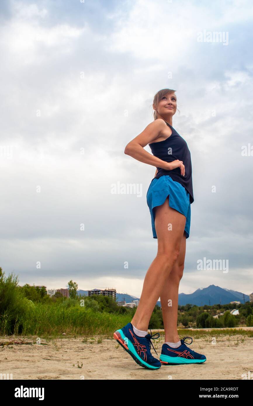Fitness woman runner relaxing after city running, Girl looking and enjoying view Stock Photo
