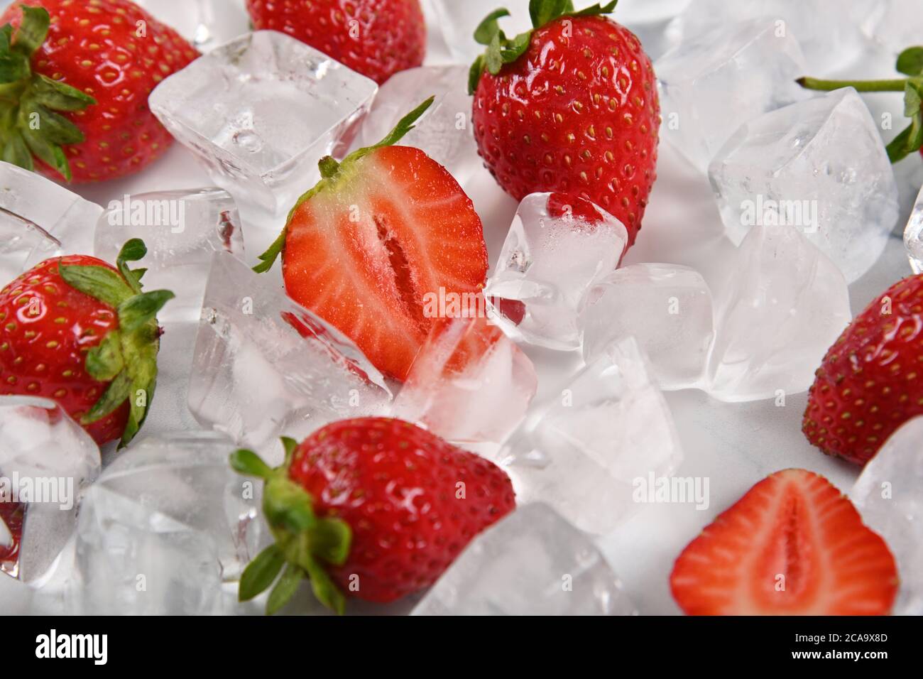 Close up fresh red ripe strawberries and ice cubes on table, high angle view Stock Photo