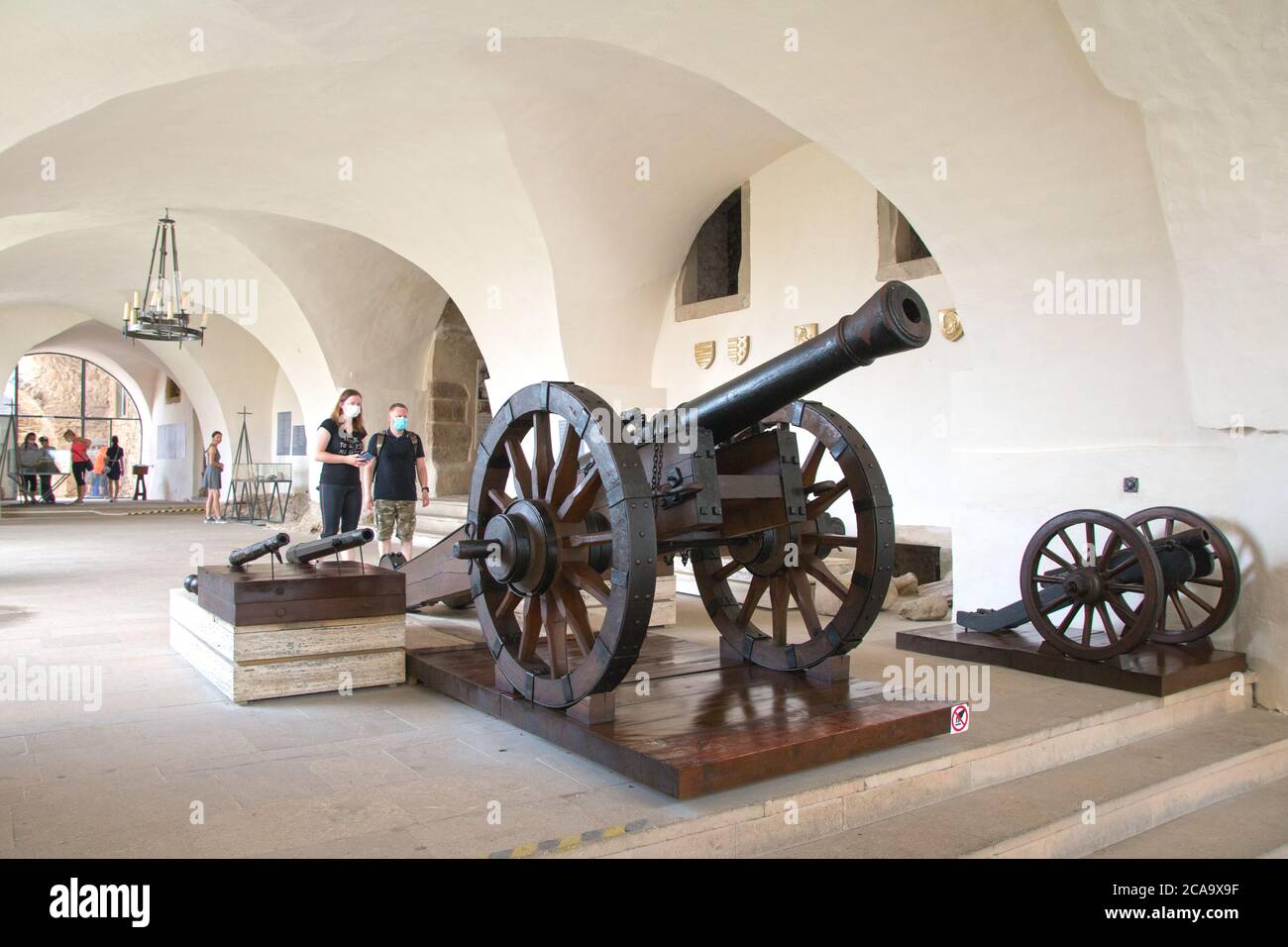 Spišské Podhradie Slovakia July 31, 2020 Old wooden wheeled cannons in the museum of the Spisské Hrad fortress. Visitors wear a covid mask. Stock Photo