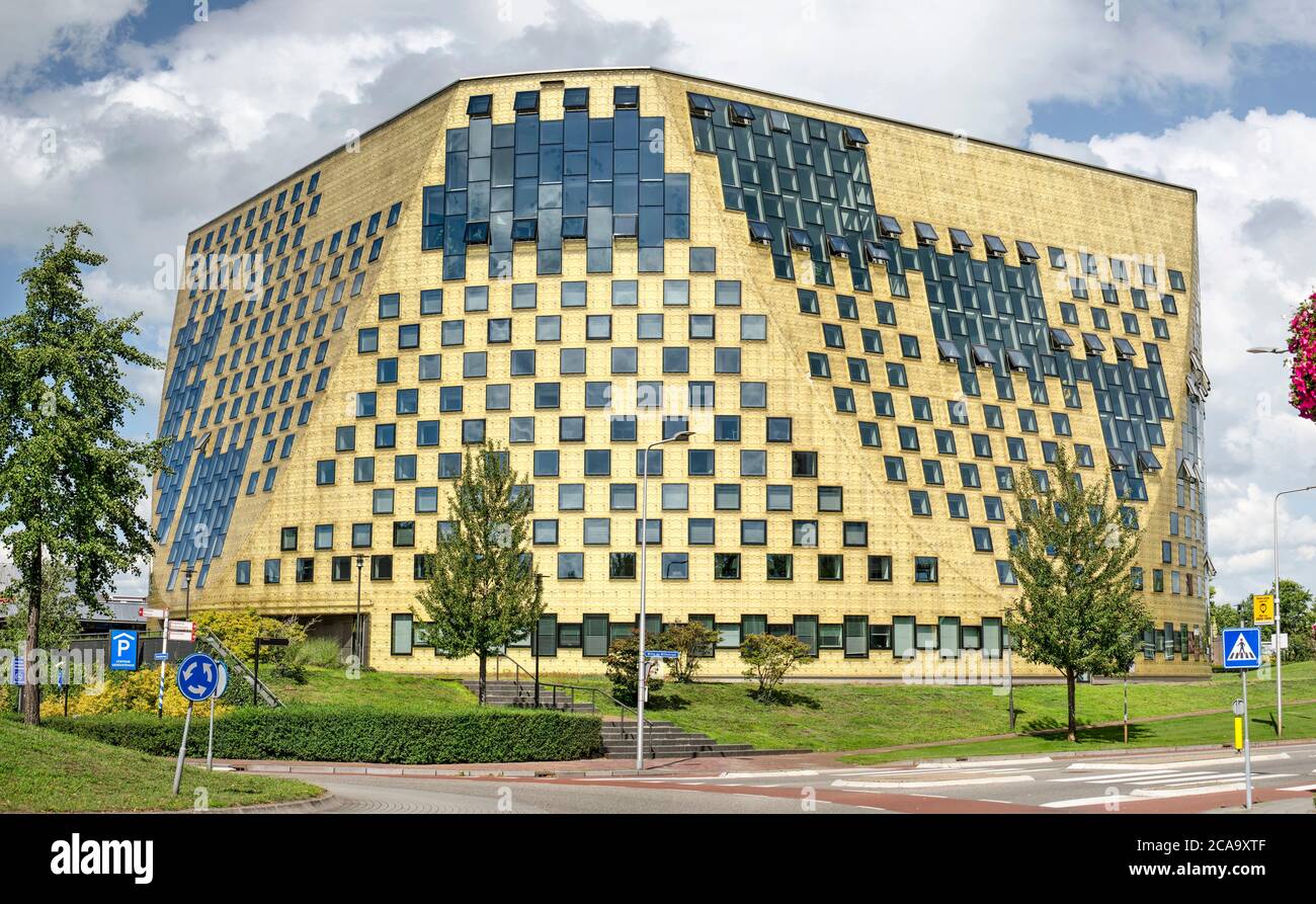 Hardenberg, The Netherlands, July 28, 2020: The scultural and compact shape of the new town hall with its 'golden' facade and surrounding park Stock Photo