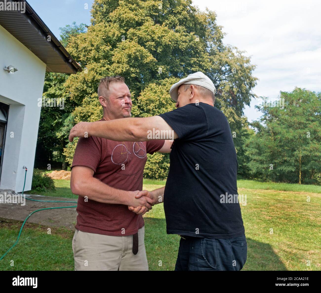 Polish father and son-in-law shaking hands and hugging for a good-by. Zawady Gmina Rzeczyca Poland Stock Photo