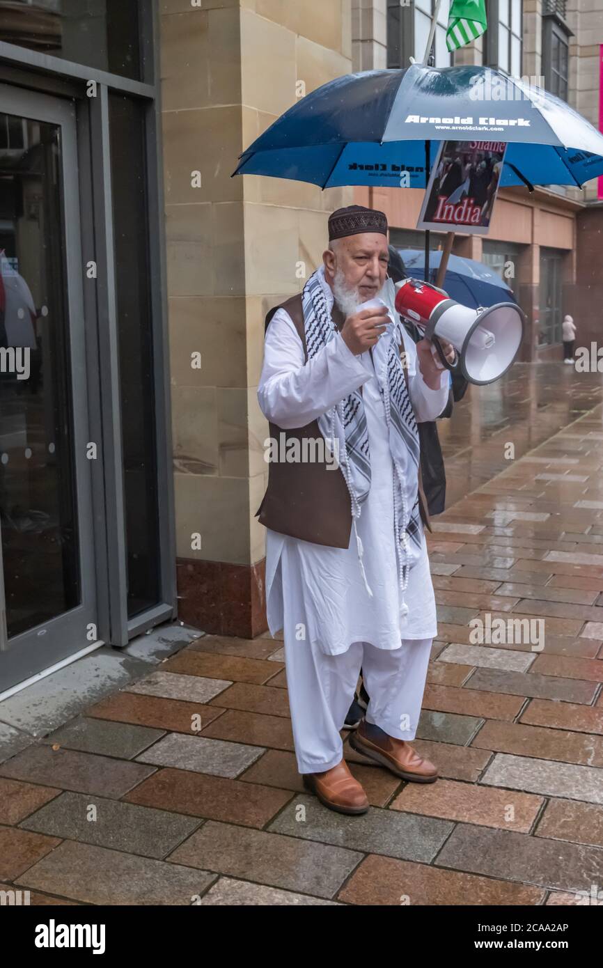 Glasgow, Scotland, UK. 5th August, 2020. A protester talking through a megaphone at a rally on the steps of the Royal Concert Hall against human rights violations and atrocities in Kashmir at the hands of the Indian Occupation Forces. Credit: Skully/Alamy Live News Stock Photo