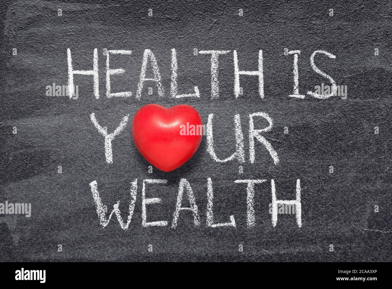health is your wealth phrase written on chalkboard with red heart symbol Stock Photo
