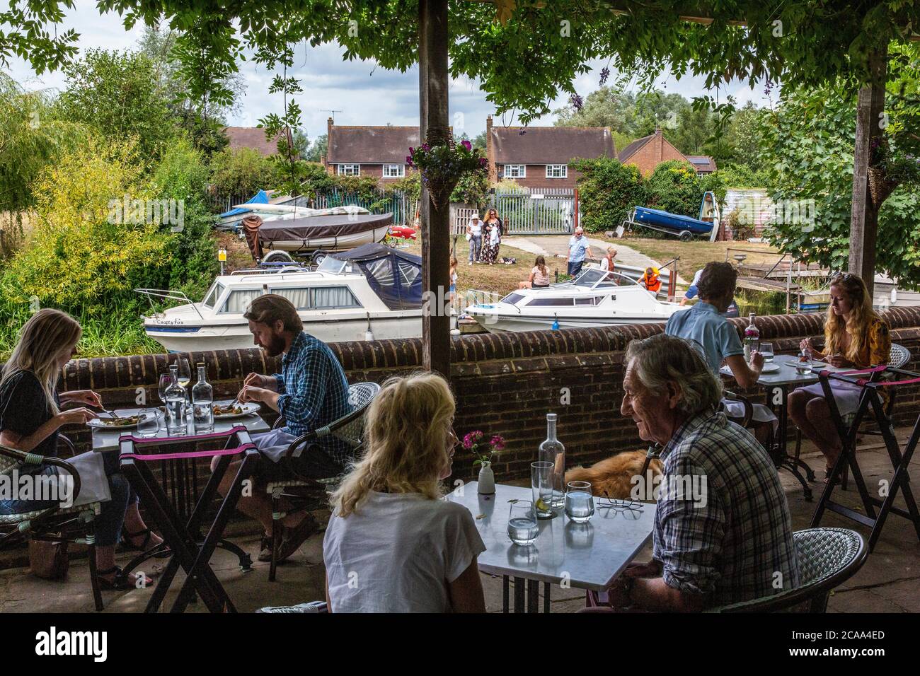 People siting on the riverside terrace overlooking Great Stour river eating al fresco at the Fordwich Arms, Fordwich, Kent, England, United Kingdom Stock Photo