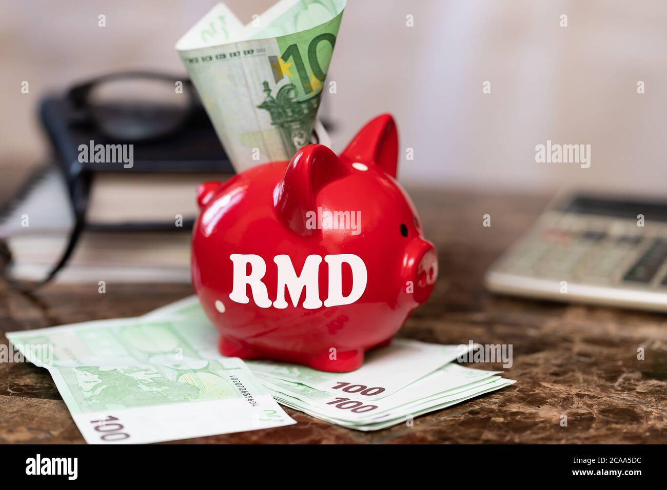 RMD require minimal distribution on the heading. The inscription on a piggy bank standing on a bundle of banknotes Stock Photo