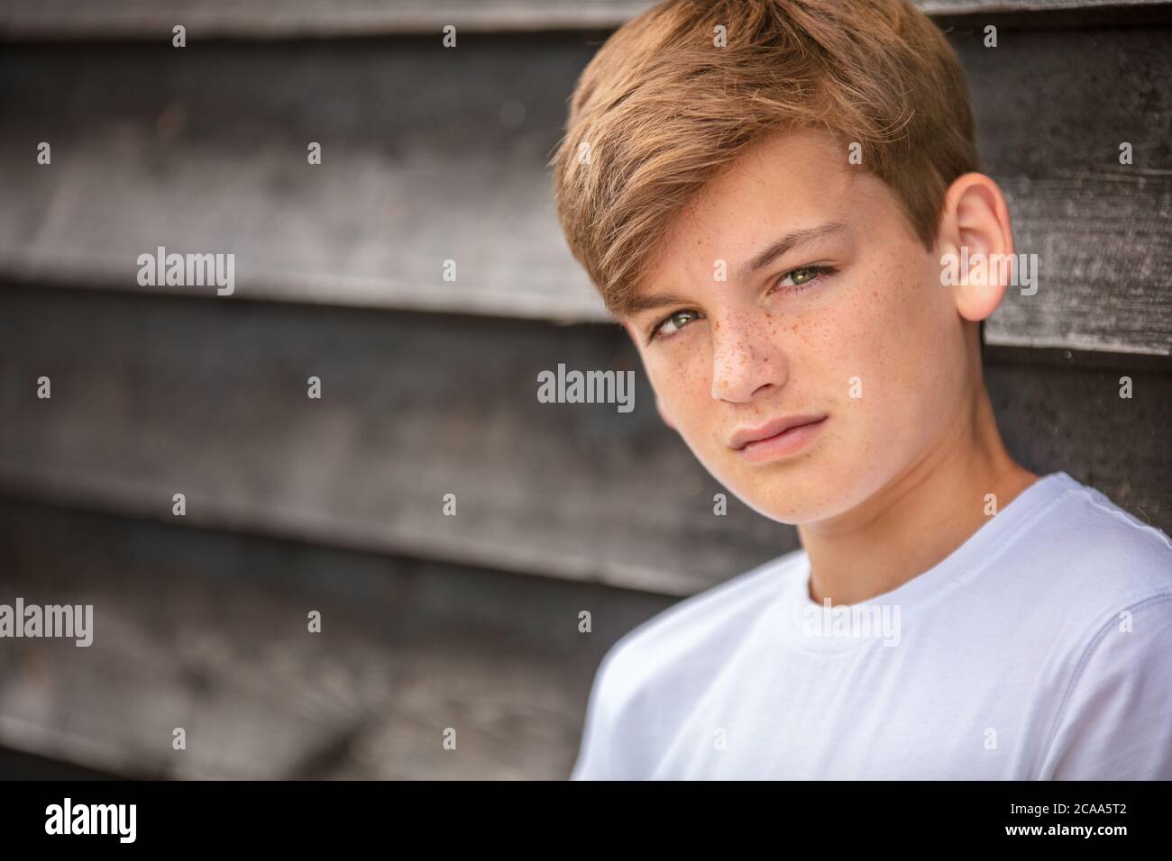 Portrait of a boy teenager teen male child wearing a white t-shirt outside Stock Photo