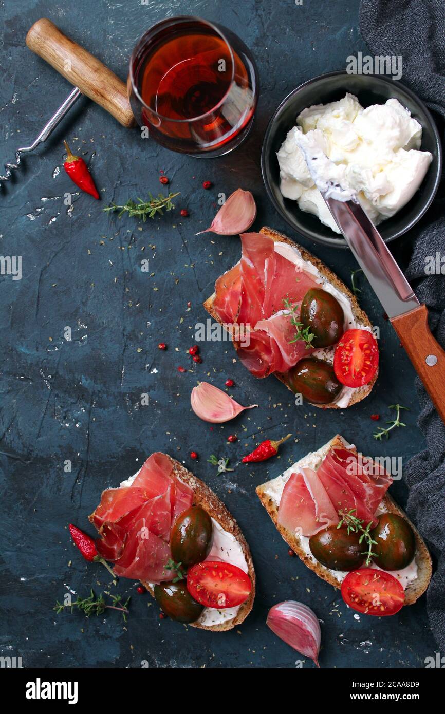 Bruschetta set with prosciutto, tomato and light cheese for wine. Top