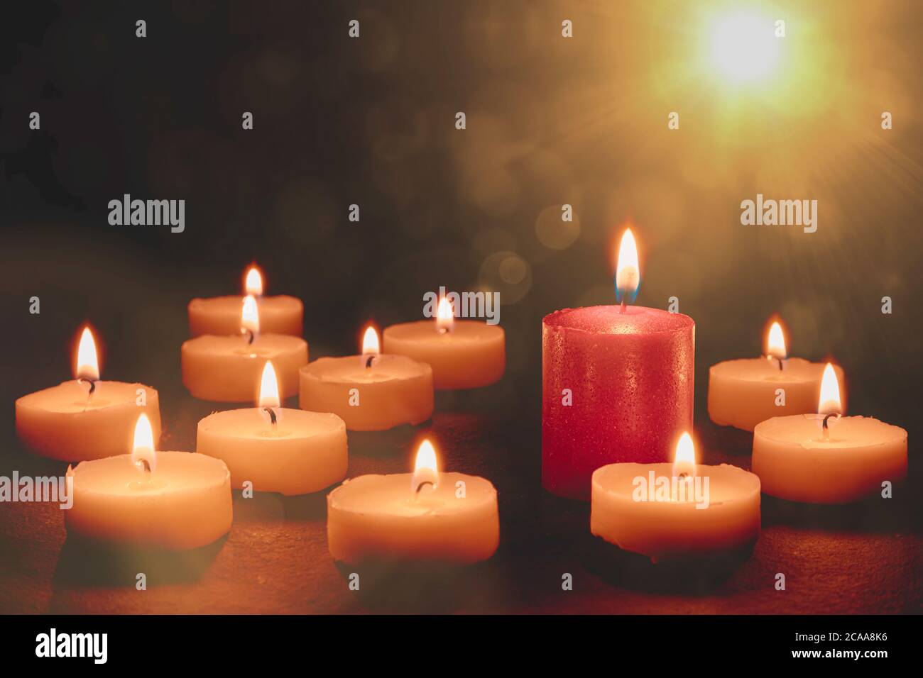 Many white candles ond one red candle. Bokeh and flares Stock Photo Alamy