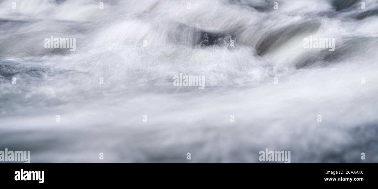 Long exposure photo - water flowing over rocks everything smooth, only few waterdrops in focus Stock Photo