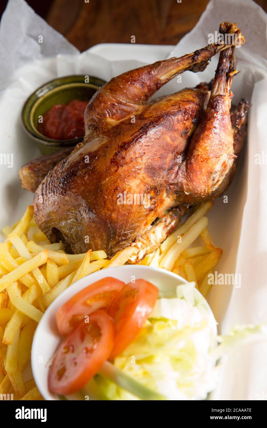 A homecooked pheasant that was shot on a driven pheasant shoot that has been roasted and served with chips and salad in a basket as an alternative to Stock Photo