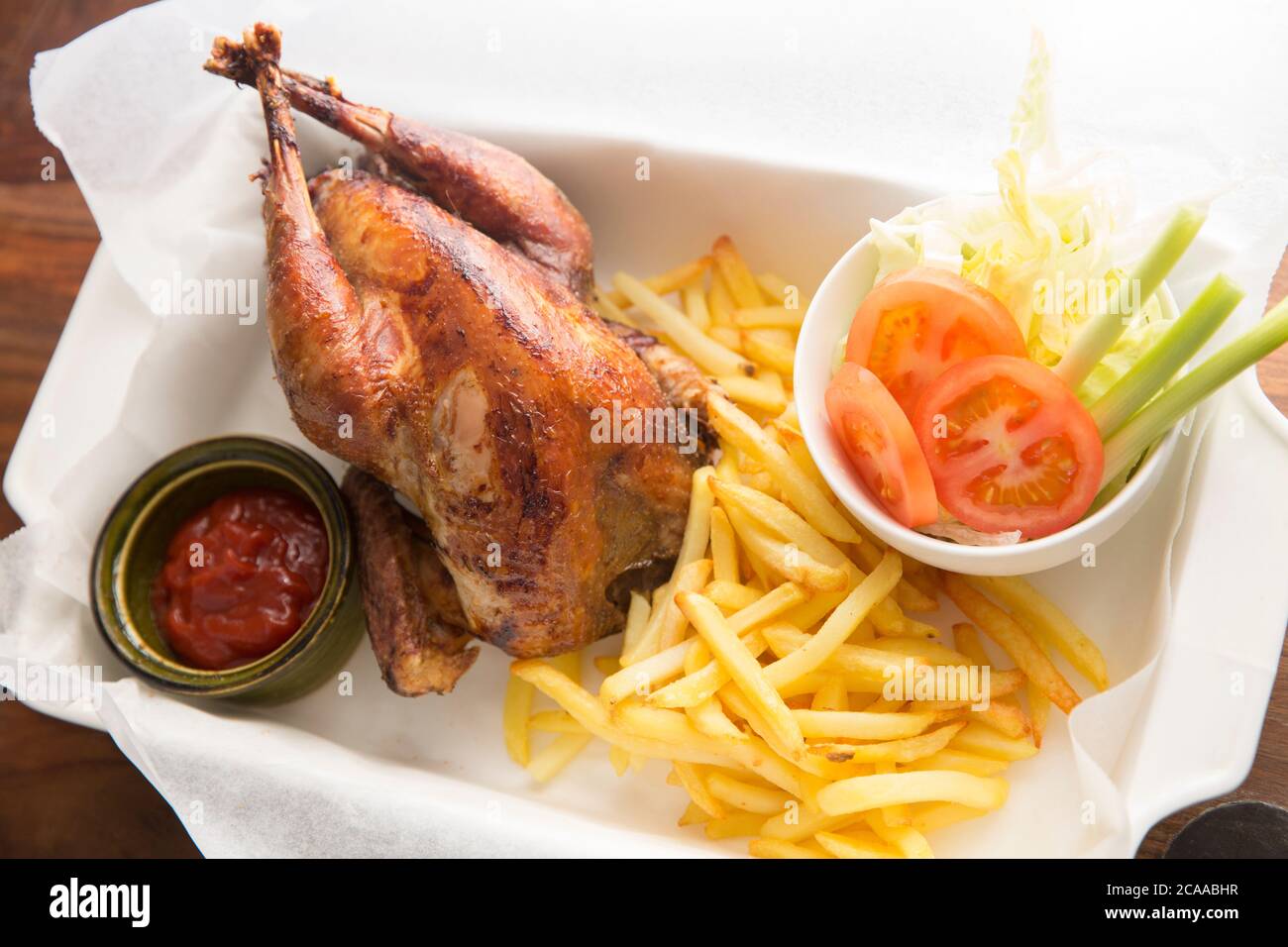 A homecooked pheasant that was shot on a driven pheasant shoot that has been roasted and served with chips and salad in a basket as an alternative to Stock Photo